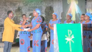 Mrs. Cynthia Obu on behalf of the OLA Parish Women Council marking a presentation to Mr. George Agbenyegah, a member of the St. Vincent de Paul Society. Credit: OLA Parish Catholic Women Council